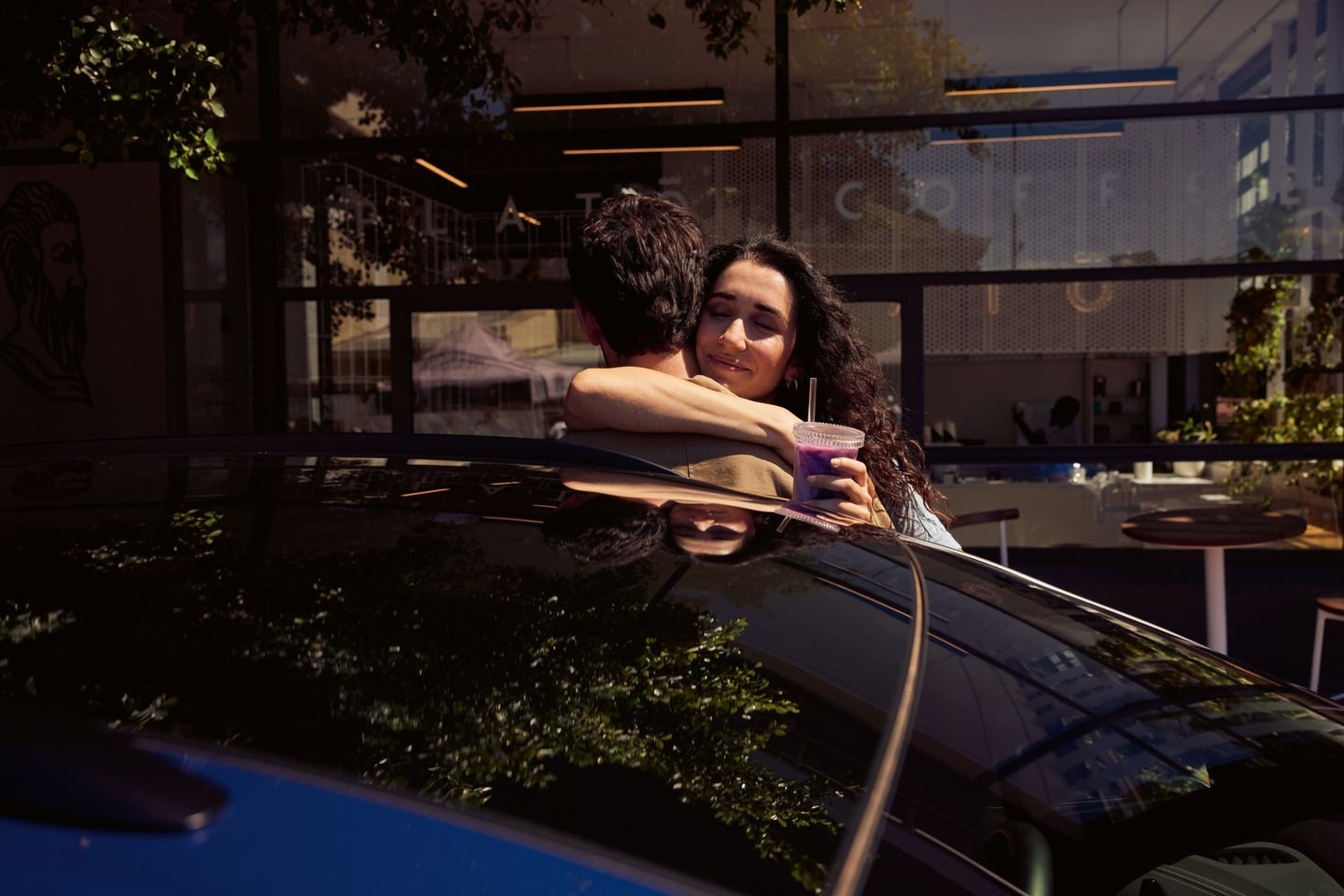 Zwei Personen umarmen sich hinter dem ID.4. 