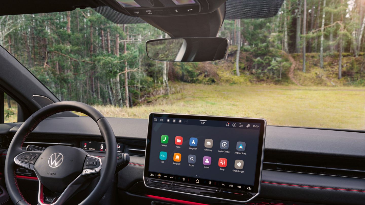 Cockpit eines VW ID.7 GTX Tourer mit Multifunktionslenkrad und Infotainmentsystem mit roten Akzenten.
