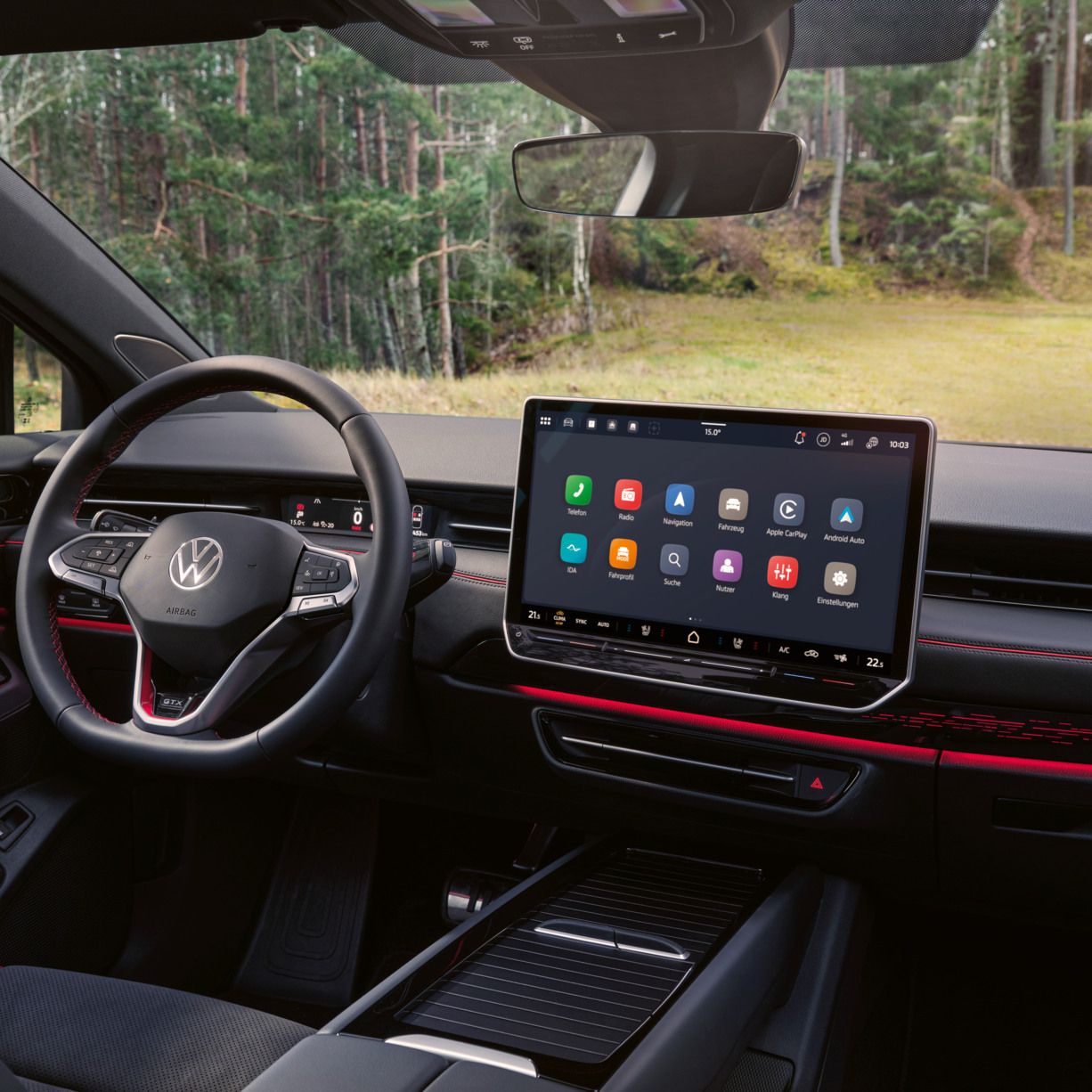 Cockpit eines VW ID.7 GTX Tourer mit Multifunktionslenkrad und Infotainmentsystem mit roten Akzenten.