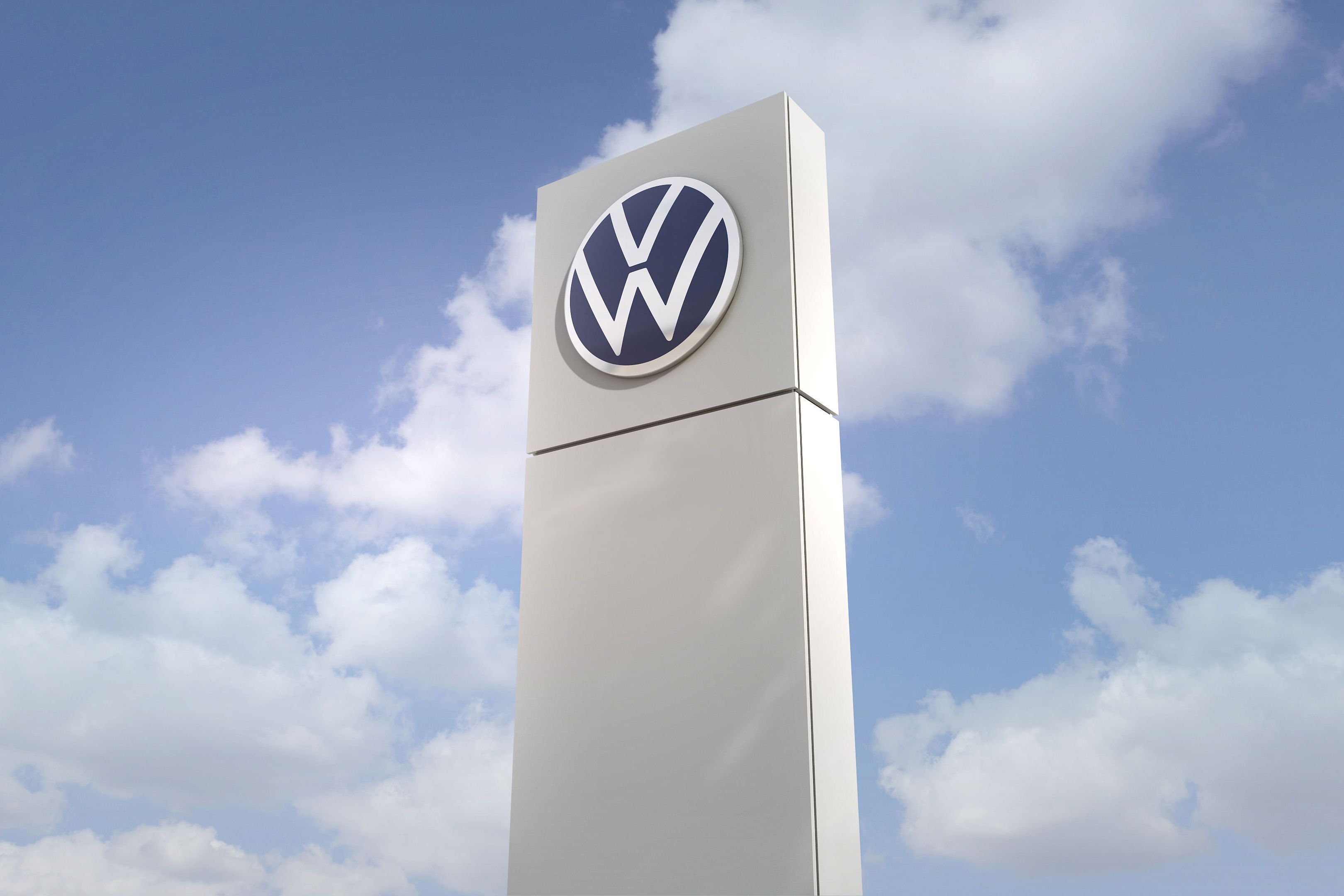Säule mit Volkswagen Logo mit Himmel im Hintergrund.