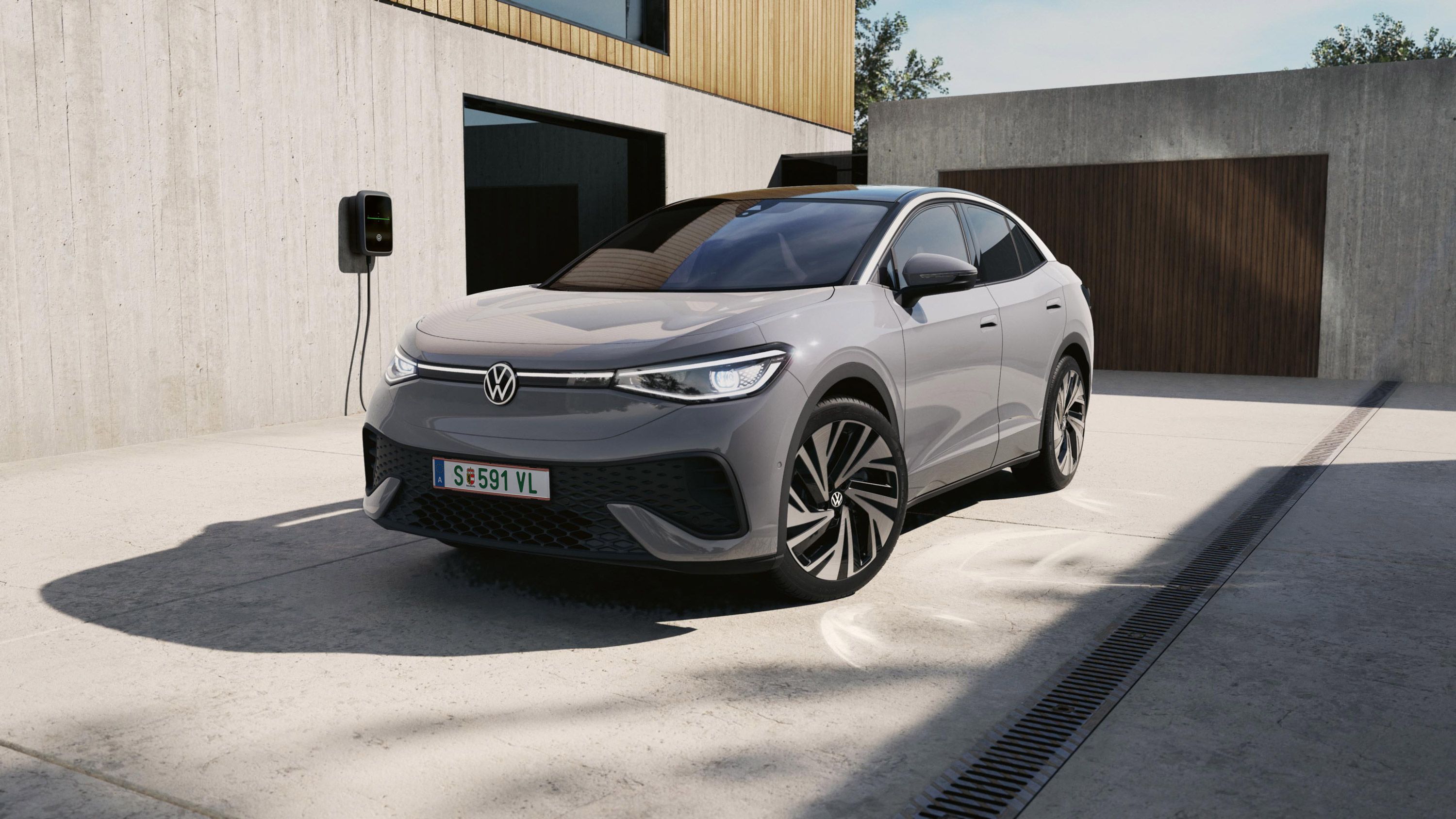 Ein grauer VW ID.5 schräg von vorne, der an einer VW Wallbox geladen wird.