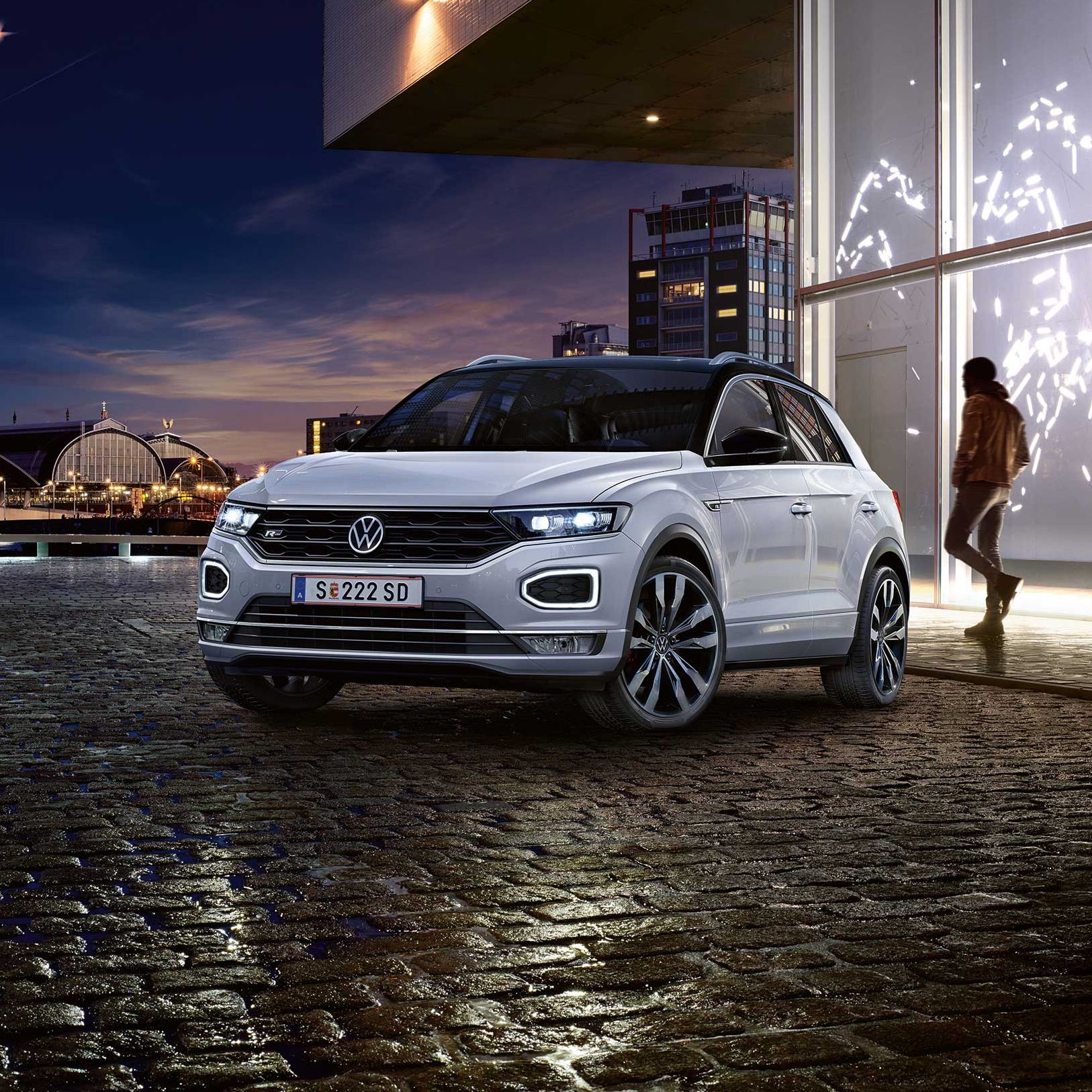 Person geht hinter VW T-Roc Vorgängermodell