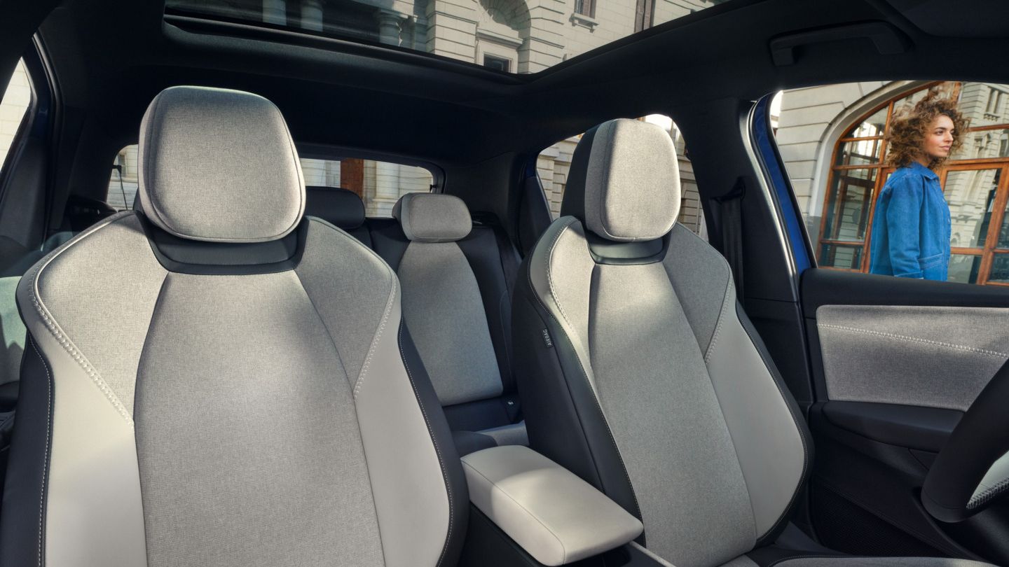 Massagesitze im VW ID. Polo Style, durch die Fenster und das Panoramadach ist ein Gebäude zu sehen.