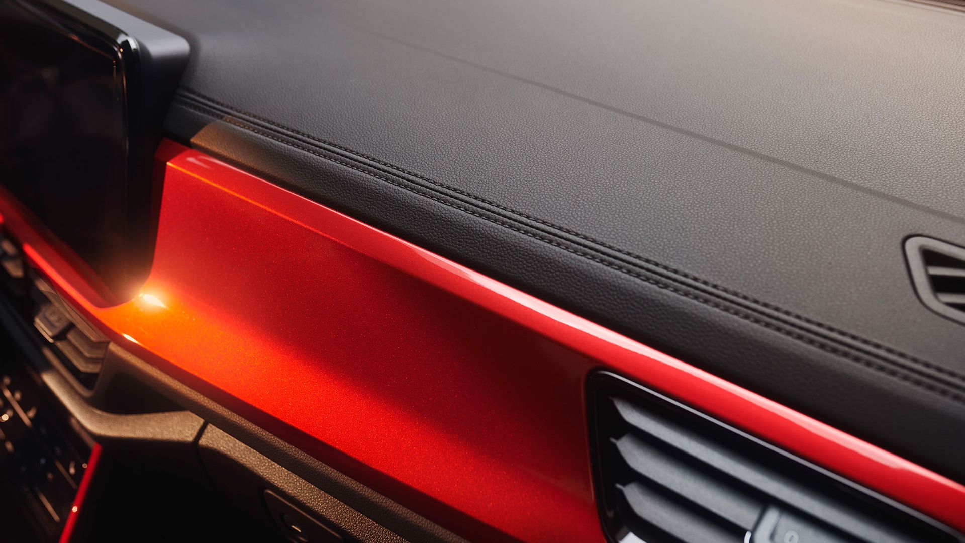 Detail der Ziernähte im Cockpit des VW T-Roc Cabriolets mit rotem Dekor.