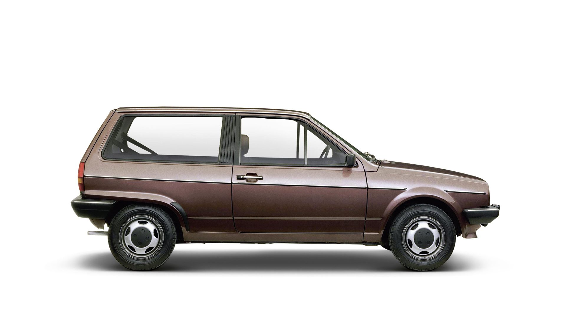 Ein VW Polo 2 von der Seite, das auf weißem Hintergrund steht. Es hat ein kompaktes Design mit zwei Türen und schwarzen Felgen.