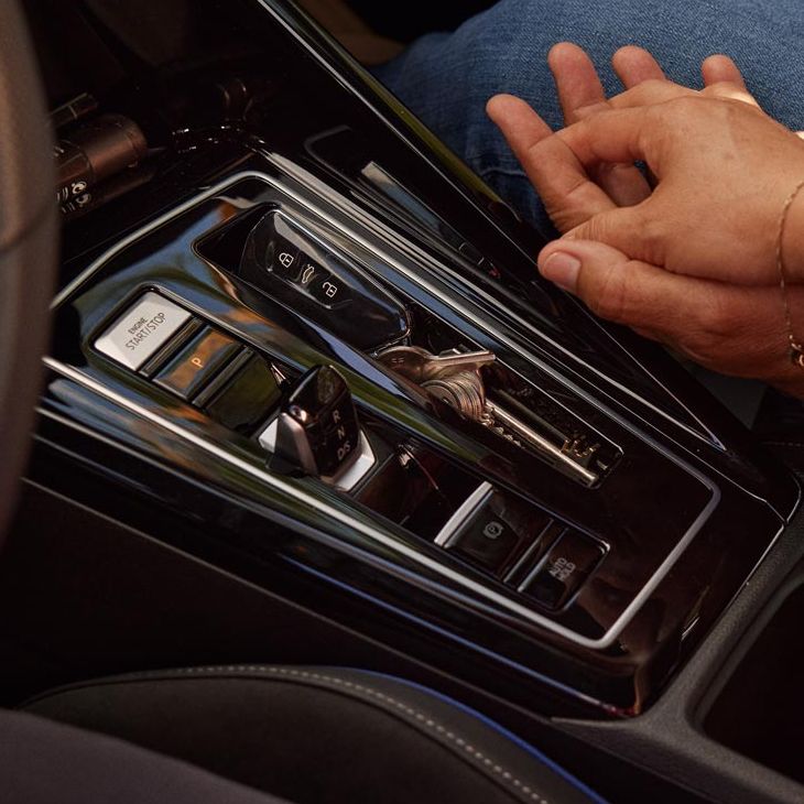 Detailansicht der Mitellkonsole und DSG/Automatikgetriebe im VW Golf, zwei Menschen halten Hände