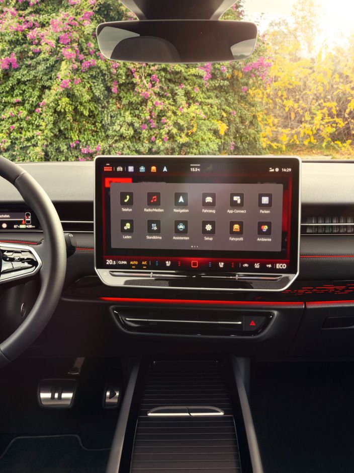 Cockpit eines VW ID.7 GTX mit Multifunktionslenkrad und Infotainmentsystem mit roten Akzenten.