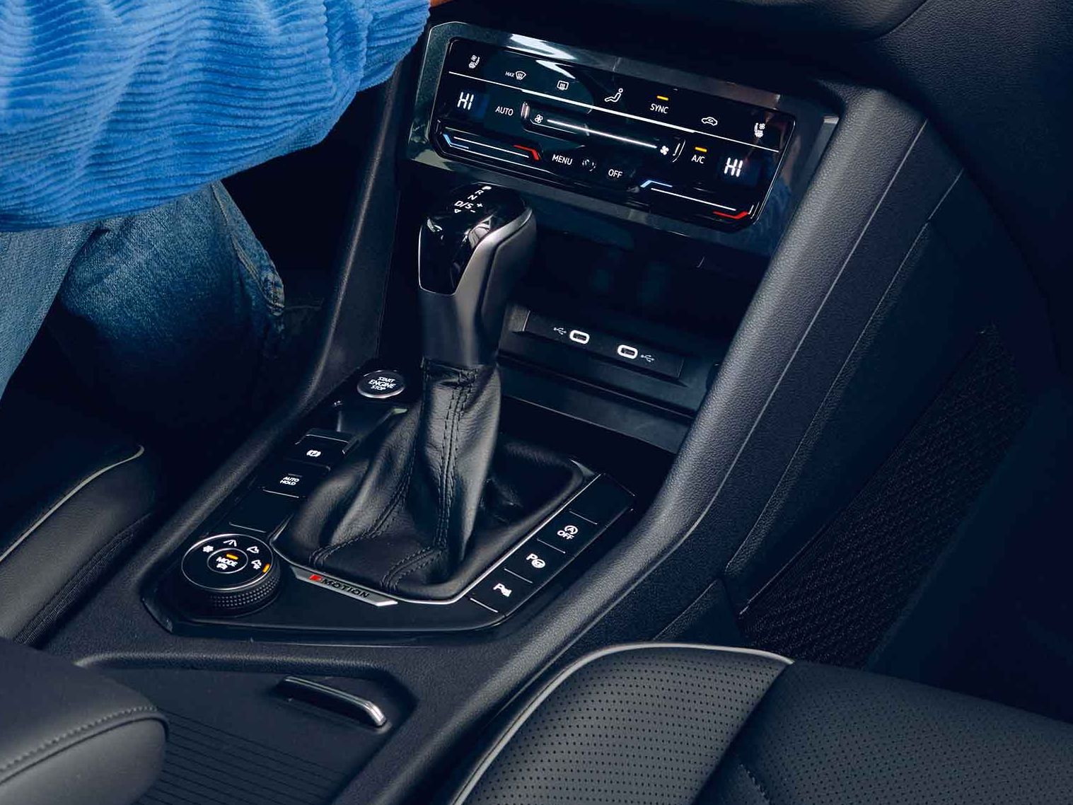 Eine Frau sitzt auf dem Fahrersitz des VW Tiguan Allspace und bedienet das Navigationssystem