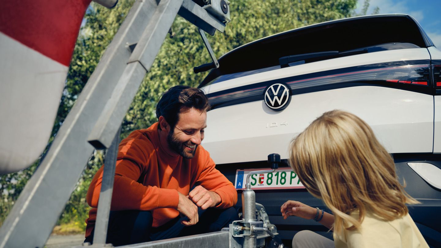 Tochter und Vater und montieren Anhänger am VW ID.4