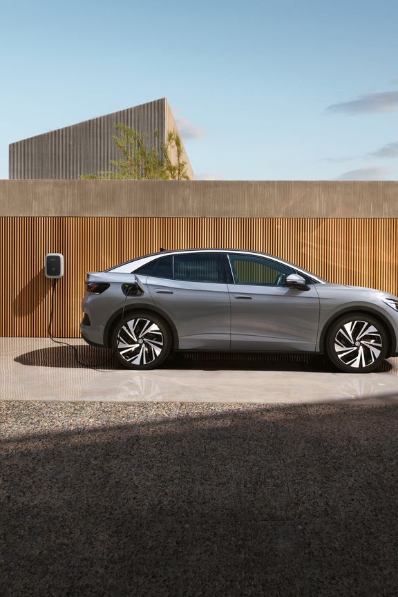 Seitenansicht eines grauen VW ID.5, der an einer Wallbox aufgeladen wird. 