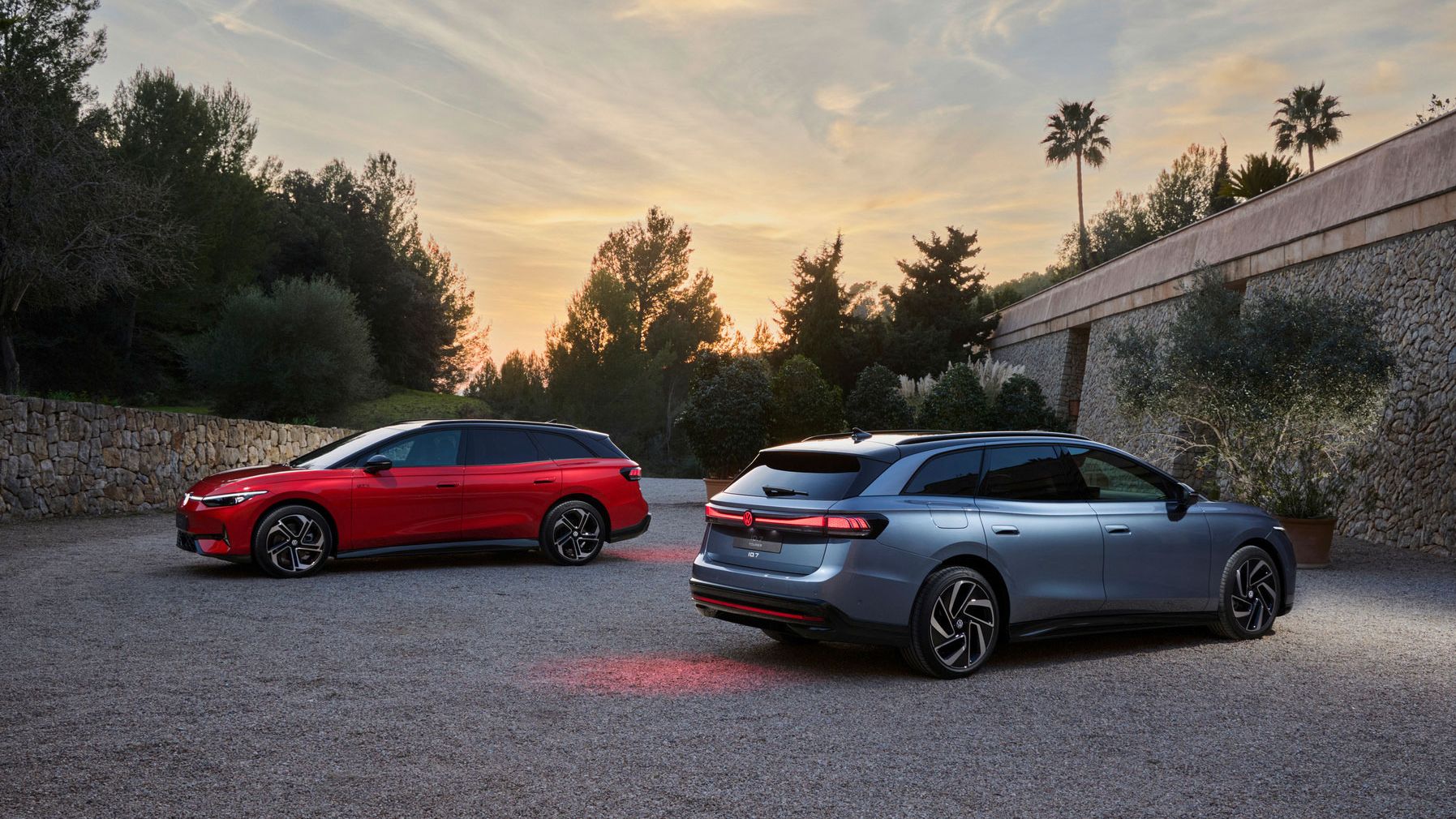 Ein roter VW ID.7 Tourer GTX und ein silberner ID.7 Tourer stehen auf einem Parkplatz. 