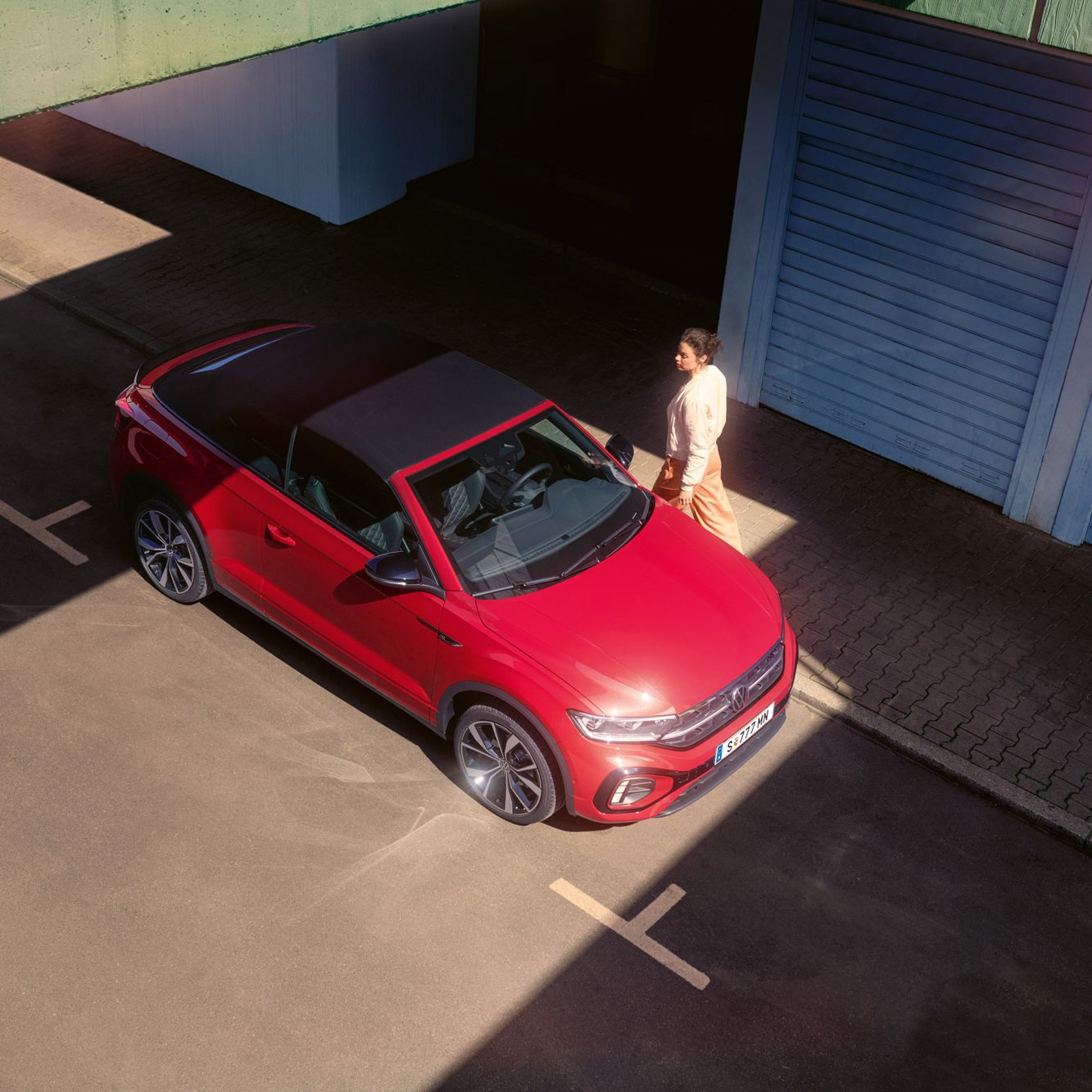 Blick von oben auf ein rotes VW T-Roc Cabriolet mit geschlossenem Verdeck.