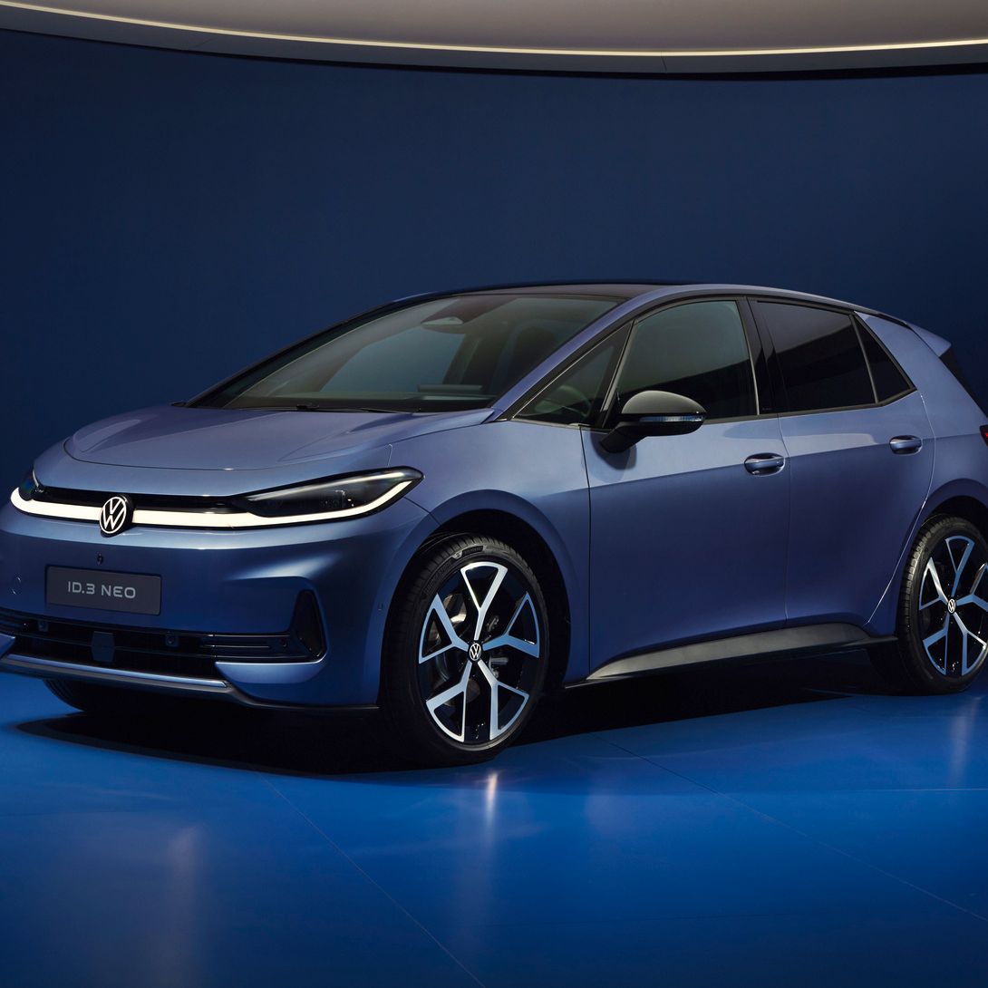 Ein dunkelblauer VW ID.3 NEO steht in einem futuristisch beleuchteten, komplett blauen Studio. Das Elektroauto ist schräg von vorne fotografiert, sodass Front und Fahrerseite gut sichtbar sind. Die Szene wirkt minimalistisch und hochwertig, mit weichem Licht und spiegelndem Boden.