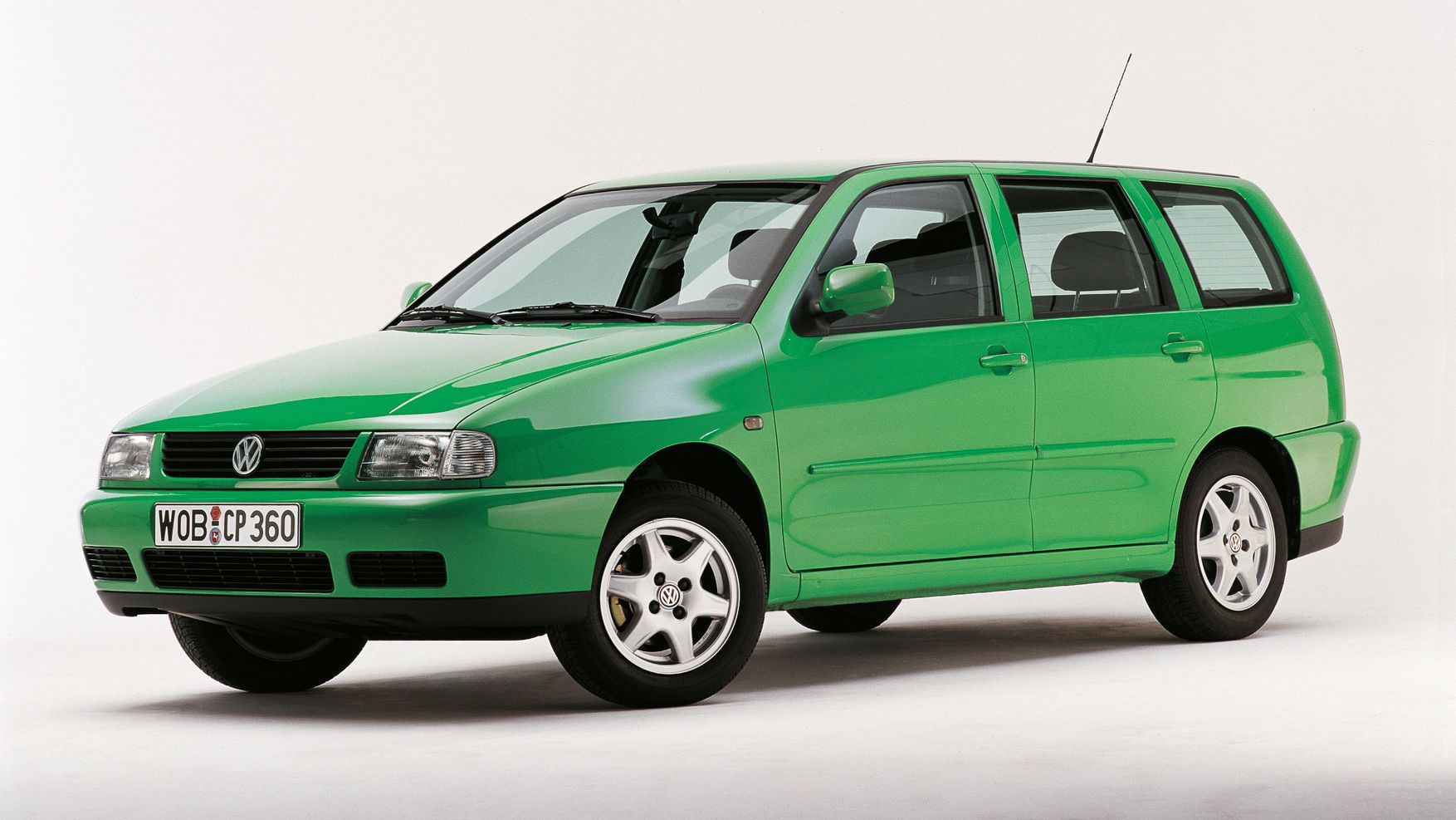 Ein grüner VW Polo 3 Variant von der Seite, vor einem weißen Hintergrund. Das Auto hat vier Türen und silberne Felgen.