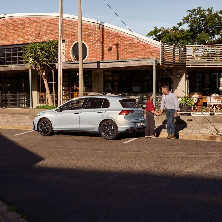 Der neue Golf GTE parkt an einem Straßenrand neben einem Café.