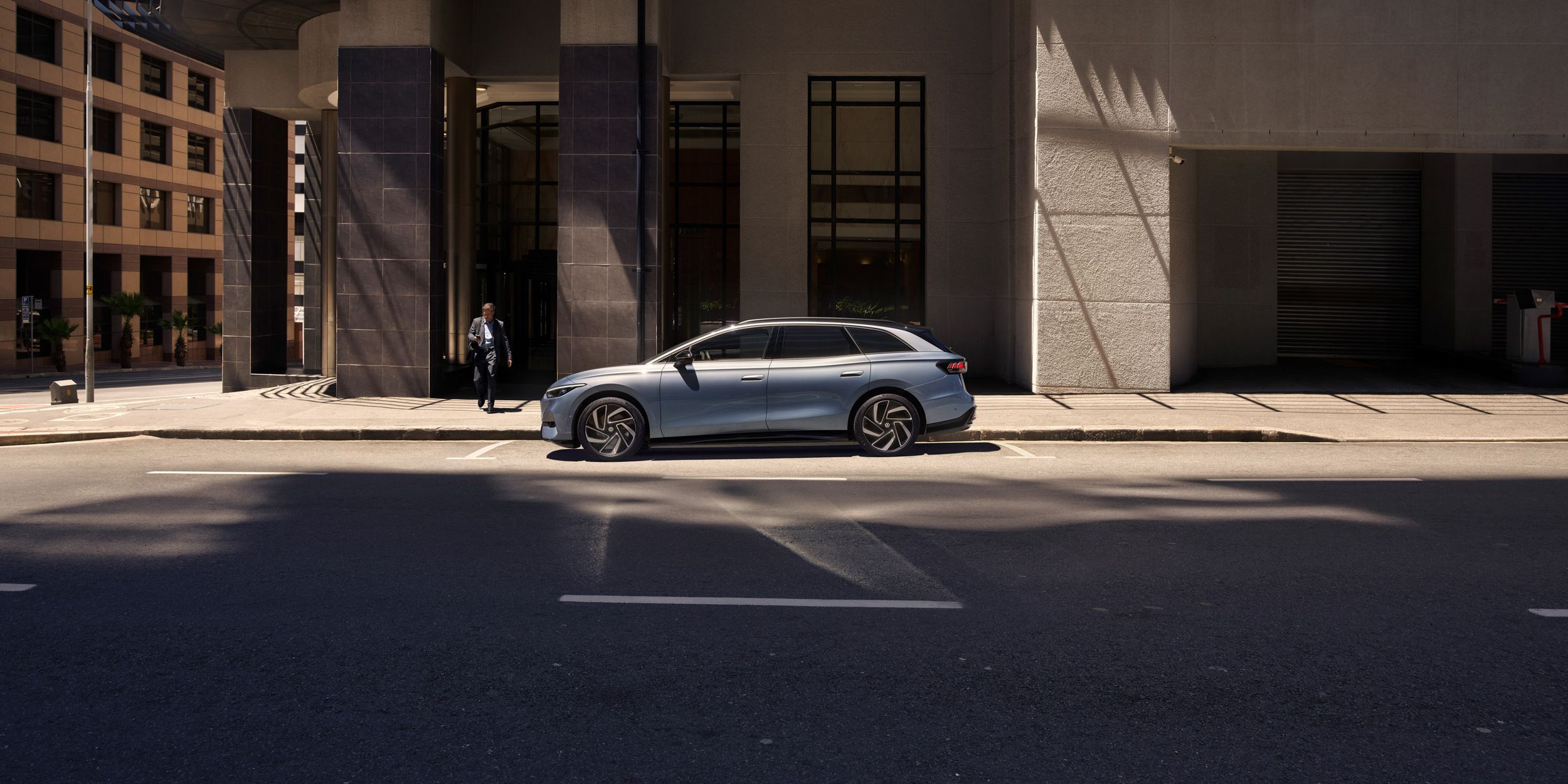 Der ID.7 Tourer steht am Straßenrand in der Stadt vor einem Gebäude