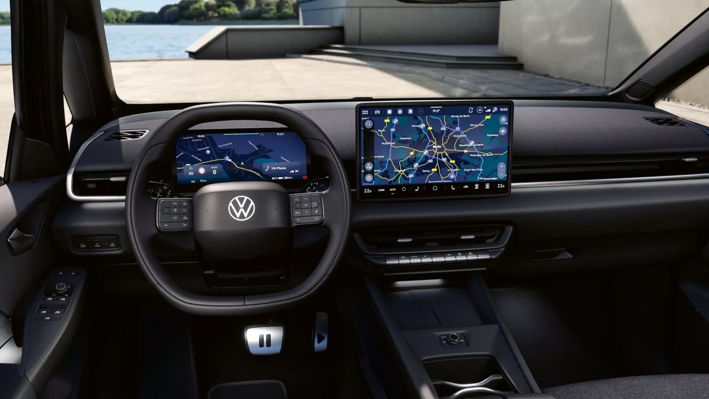 Innenraum eines ID.3 Neo Style mit Fokus auf Armaturenbrett und Lenkrad. Vor dem Fahrer ein volldigitales Kombiinstrument sowie ein großes zentrales Touchdisplay mit Navigationskarte. Die Gestaltung ist minimalistisch mit dunklen Oberflächen und wenigen physischen Tasten.