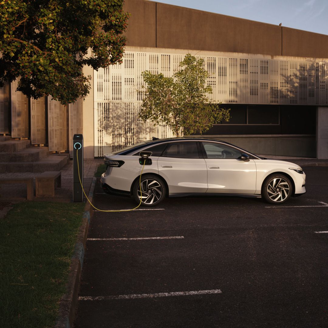 Ein weißer VW ID.7 Pro wird an einer Ladestation geladen.