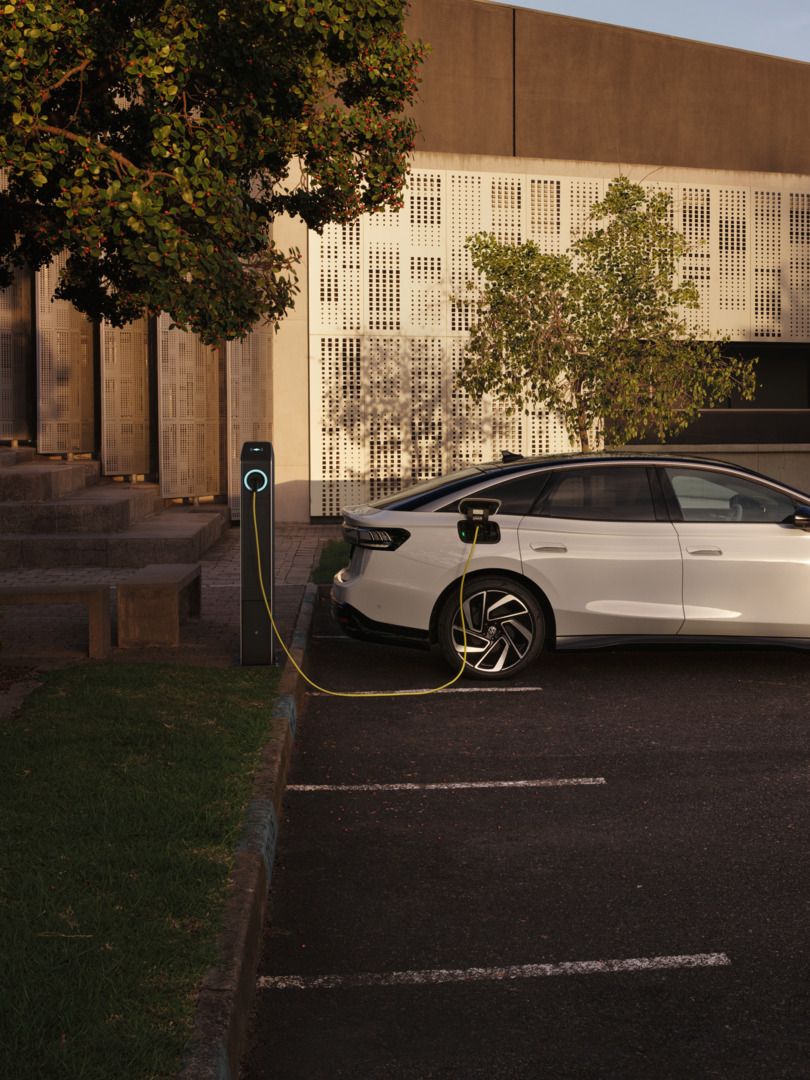 Ein weißer VW ID.7 Pro wird an einer Ladestation geladen.