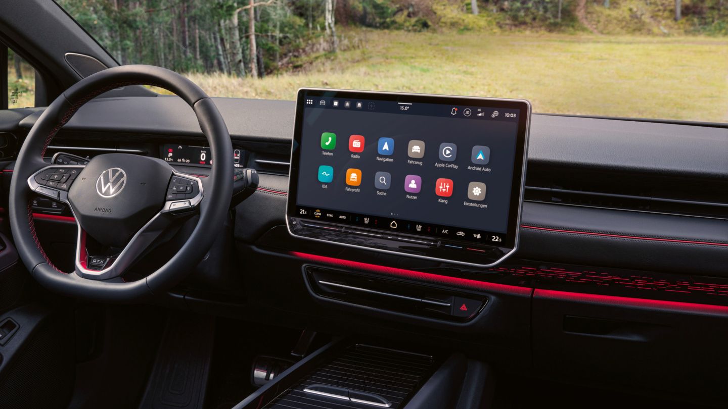 Cockpit eines VW ID.7 GTX Tourer mit Multifunktionslenkrad und Infotainmentsystem mit roten Akzenten.