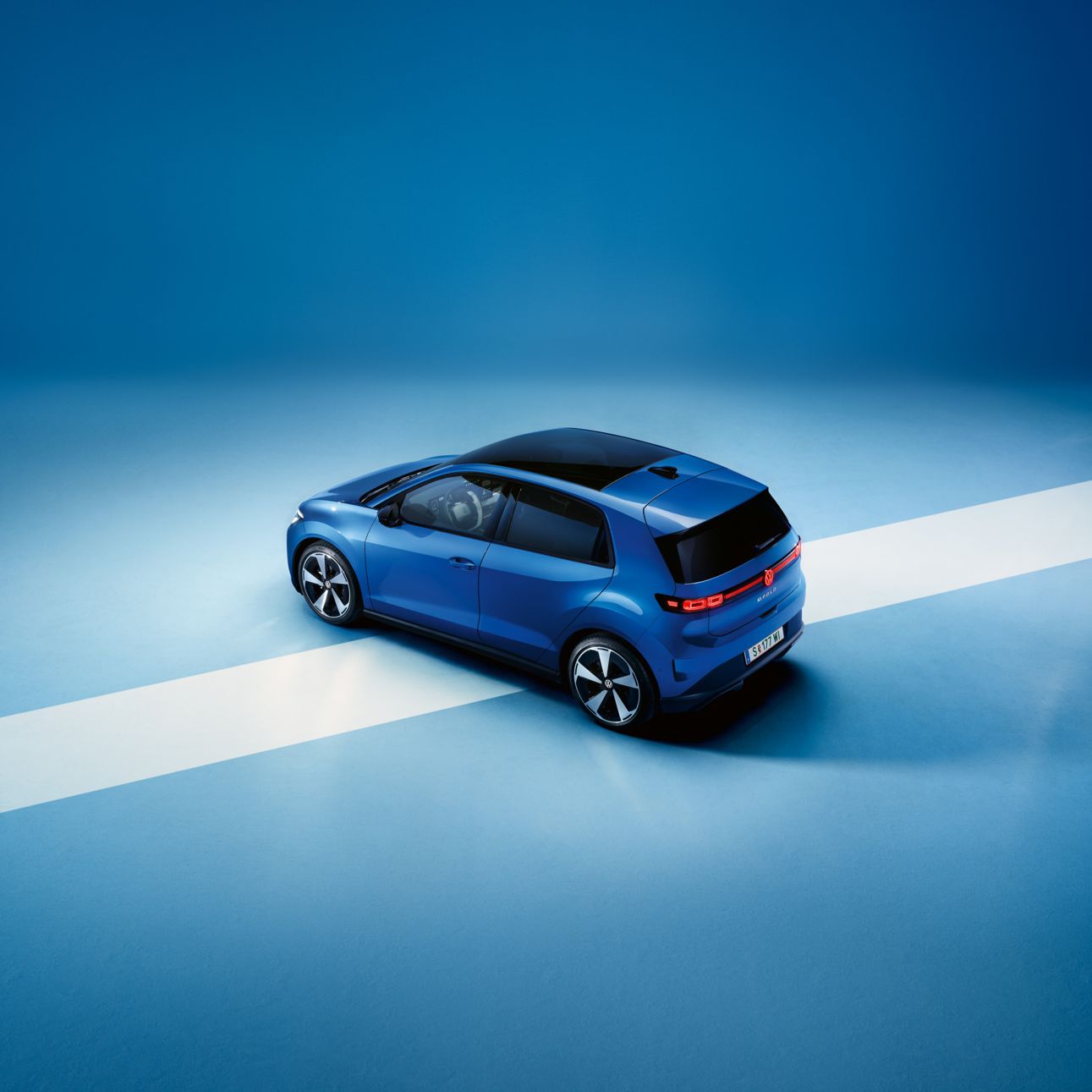 Blick von oben auf das Heck eines blauen VW ID. Polo Style vor einem hellblauen Hintergrund.