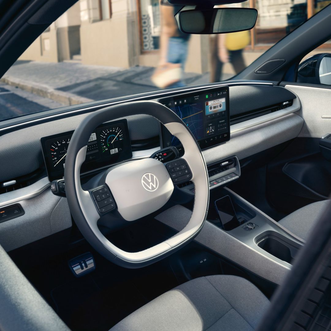Blick durch die offene Fahrertür auf das Cockpit des VW ID. Polo Style, der am Straßenrand parkt.