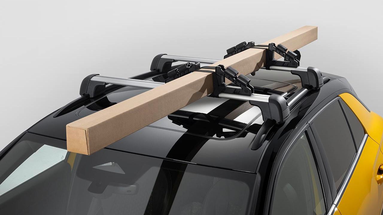 Volkswagen Dachträger mit Universalhaltern und schmalem befestigten Paket auf dem Dach eines gelben Volkswagen T-Roc.