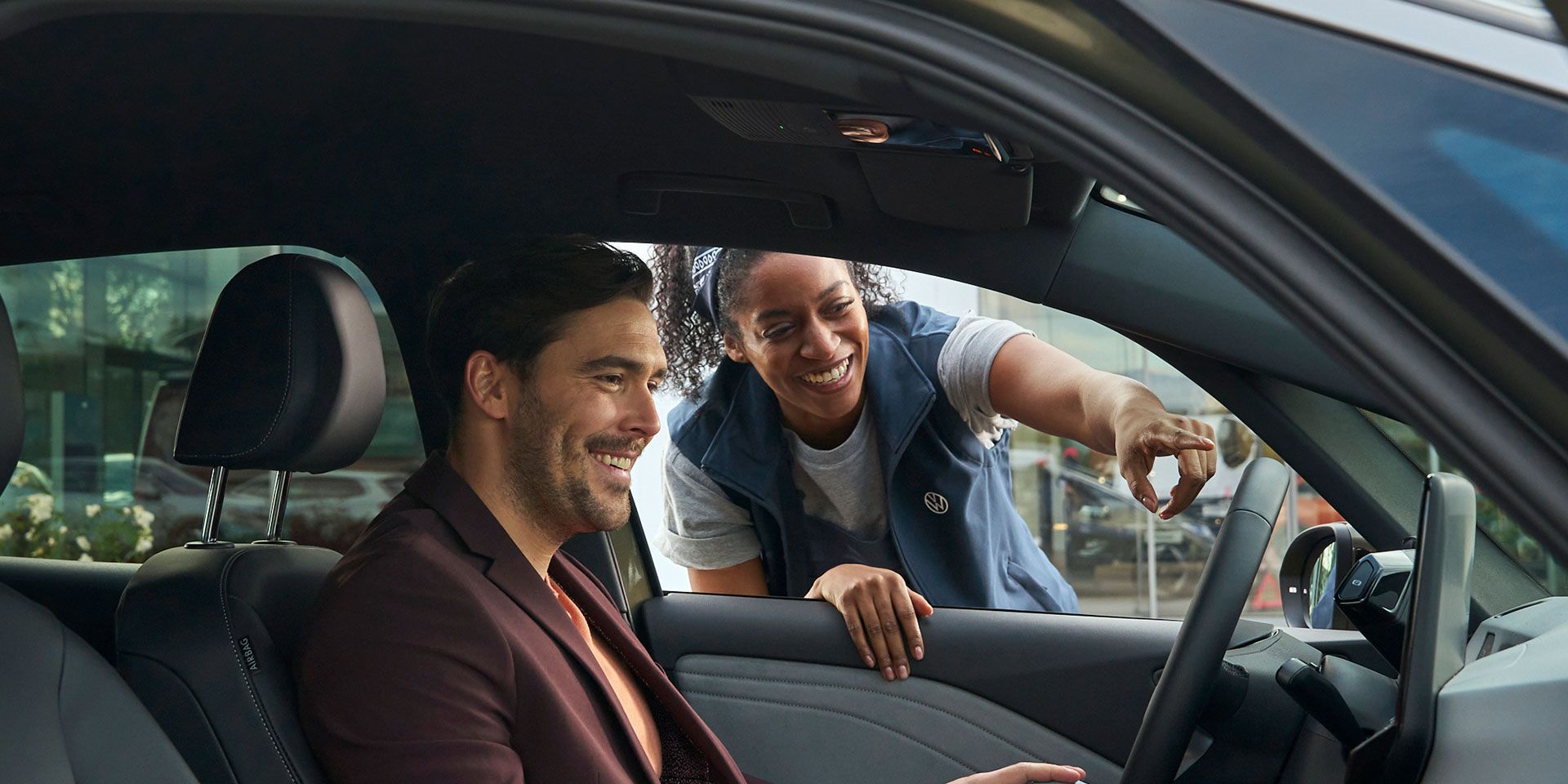 Eine Volkswagen Technikerin erklärt einem Kunden das Display in einem ID.