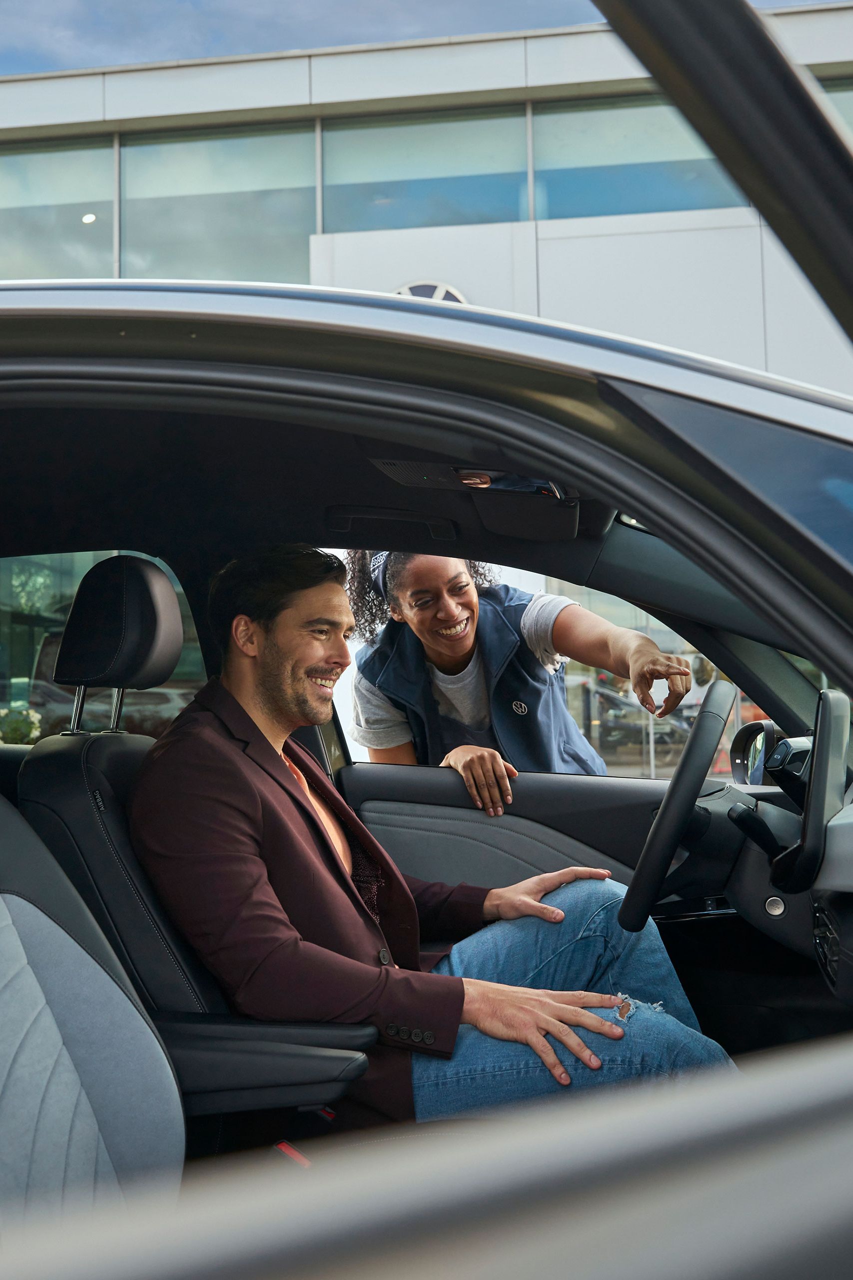 Eine Volkswagen Technikerin erklärt einem Kunden das Display in einem ID.