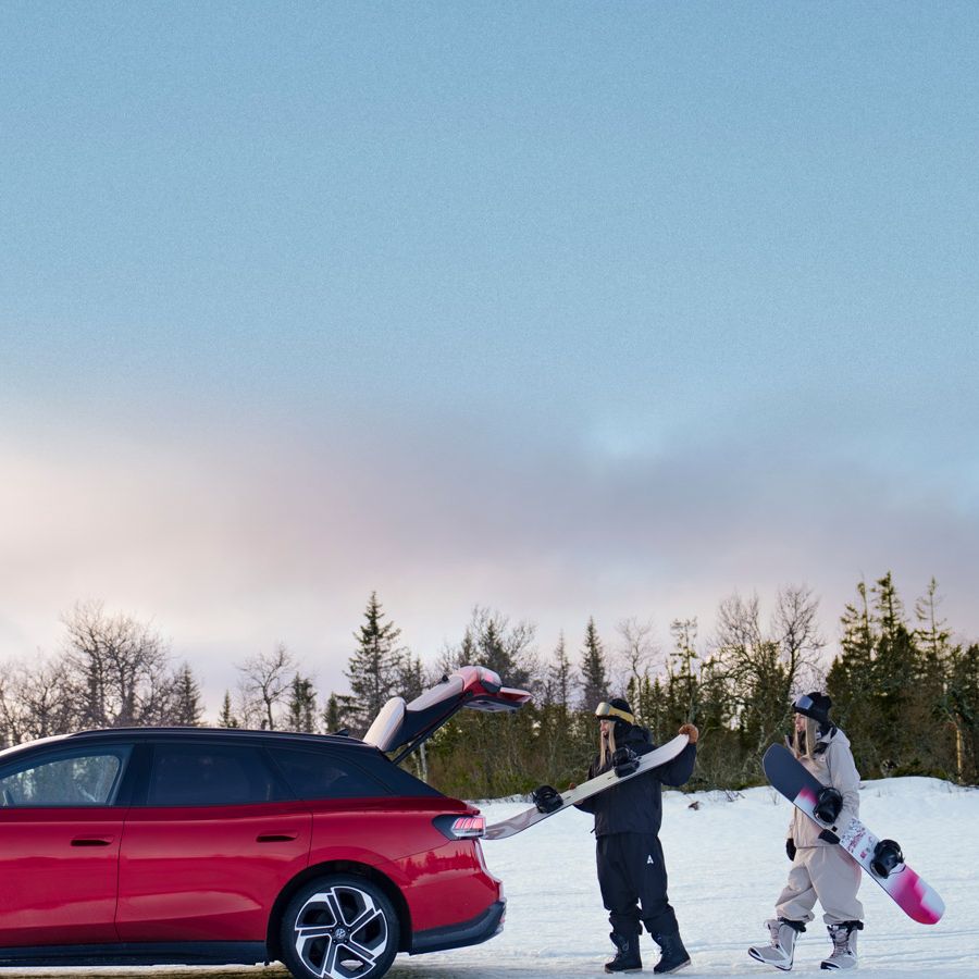 Zwei Frauen laden Snowboards in einen roten ID.7 GTX ein. 