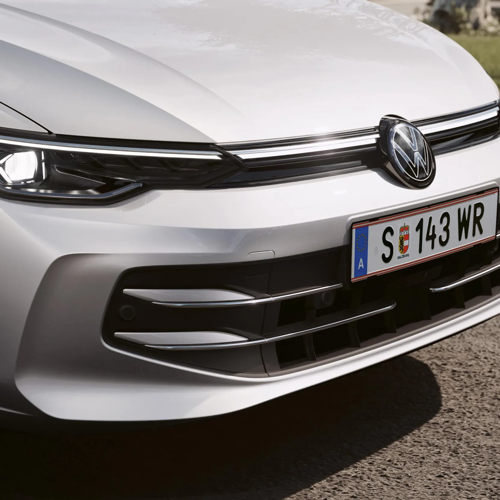 Detailansicht eines VW Golf Variant mit Front-Lichtsignatur und VW-Logo.