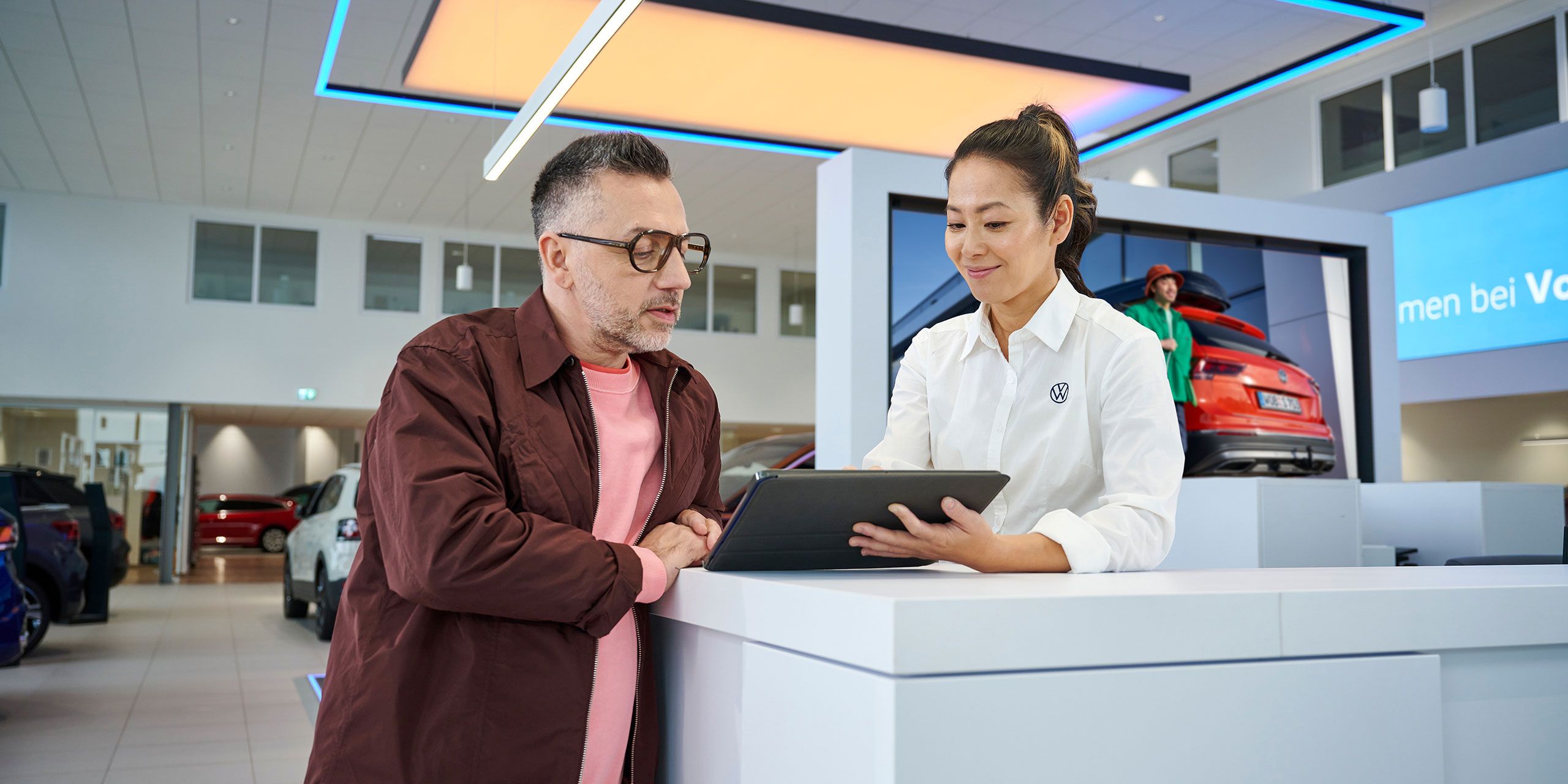 Eine Frau gibt einem Mann mithilfe eines Tablets Informationen.