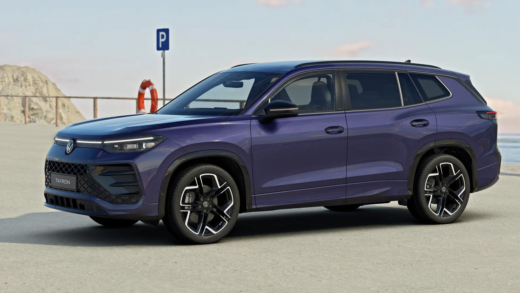 Seitenansicht eines blauen Tayron in Ultra Violet Metallic geparkt vor einer Küstenlandschaft.