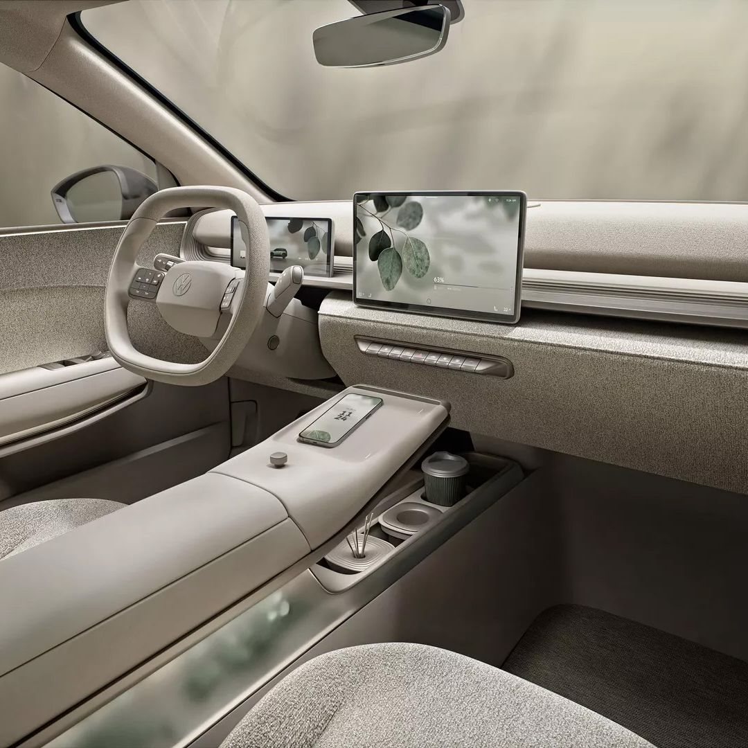 Modernes Auto-Interieur in neutralen Beigetönen im neuen ID. Cross. Zwei Bildschirme auf dem Armaturenbrett sowie eine Mittelkonsole mit mehreren Ablagefächern. Nahtlose und minimalistisch gestaltete Oberflächen.