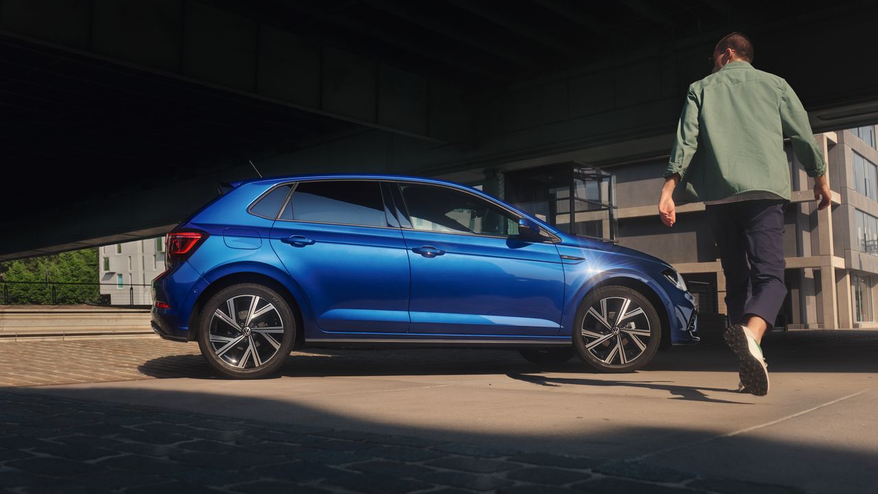 Mann geht auf blauen VW Polo R-Line zu
