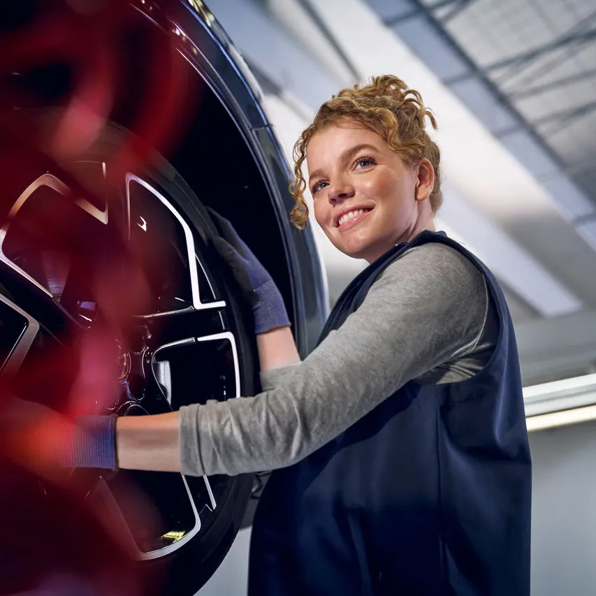 Eine Volkswagen Technikerin beim Reifenwechsel