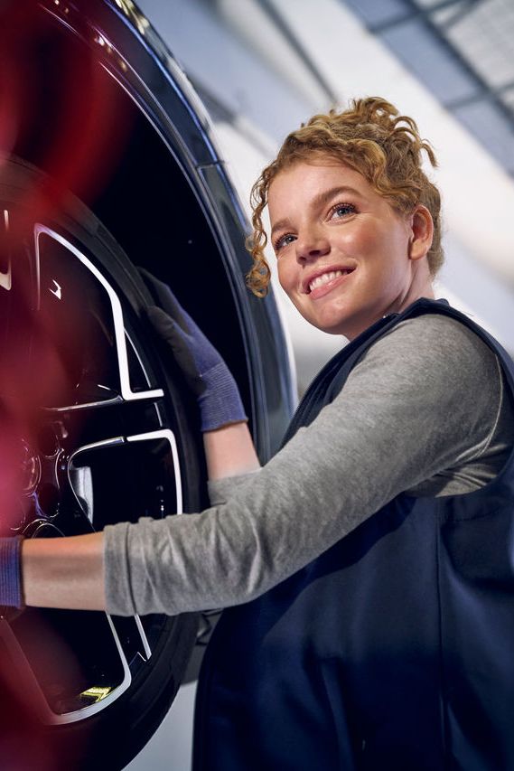 Eine Volkswagen Technikerin beim Reifenwechsel