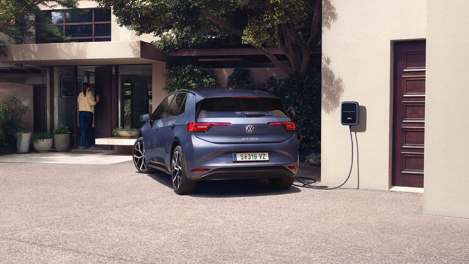 Ein blauer VW ID.3 Neo lädt an einer Wallbox vor einem Einfamilienhaus