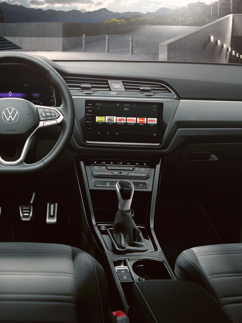 Dunkles Interieur des VW Touran R-Line mit Multifunktionslenkrad, Digital Cockpit und Infotainmentsystem. 