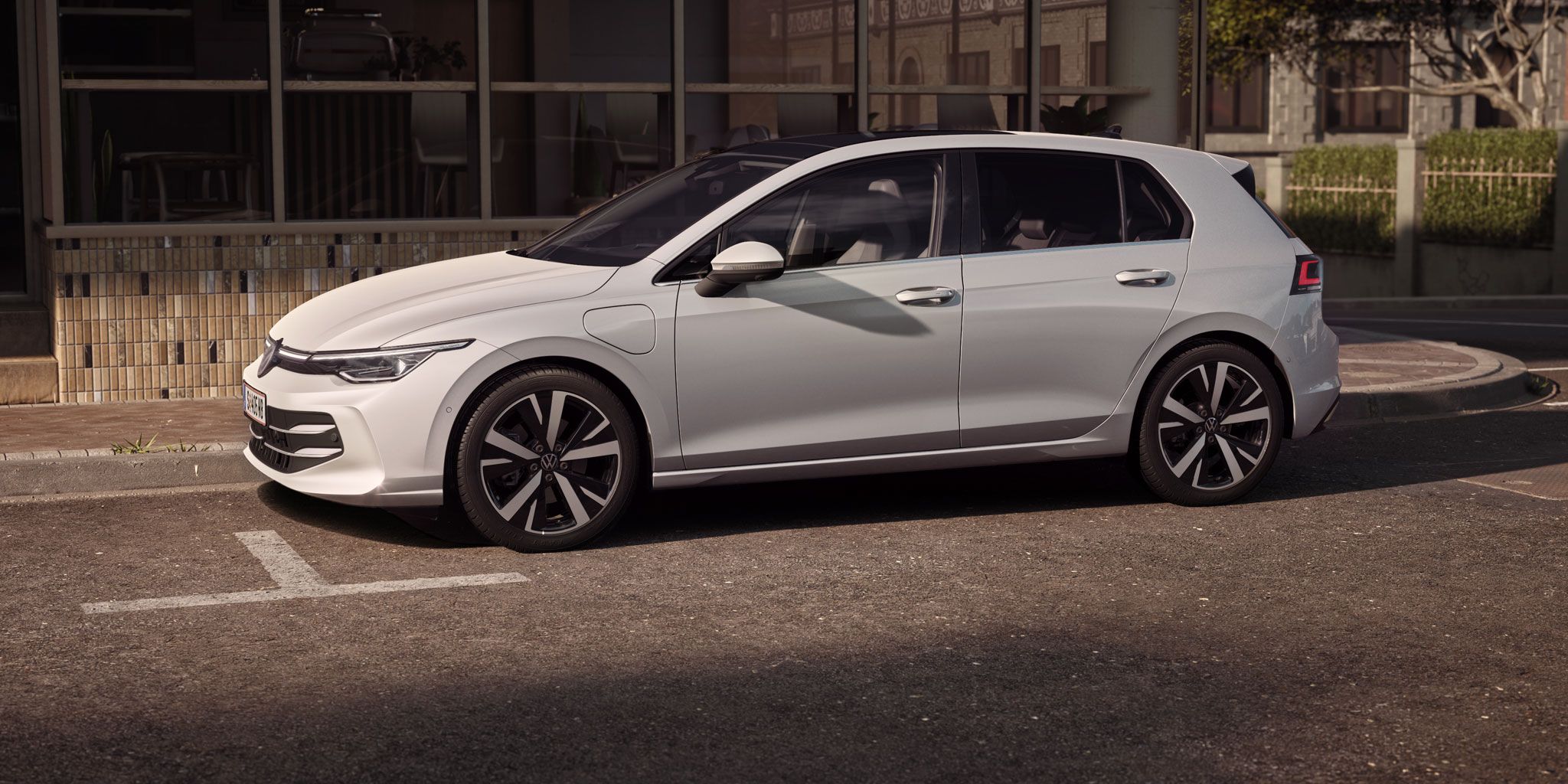 Seitenansicht eines weißen VW Golf der in Stadt geparkt ist