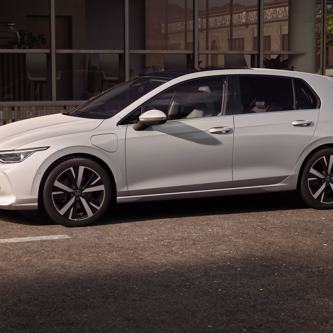 Seitenansicht eines weißen VW Golf der in Stadt geparkt ist