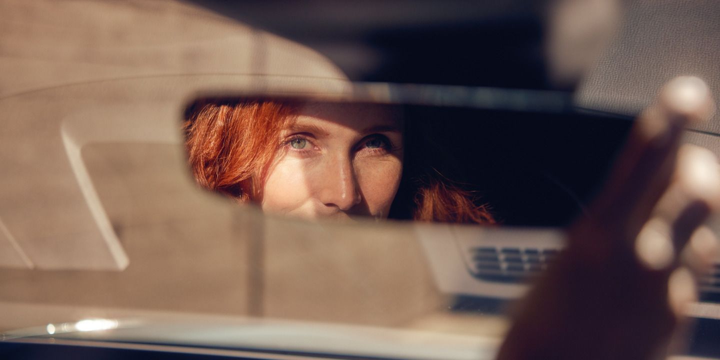 Frau richtet den Spiegel des ID.7 Tourer passend.