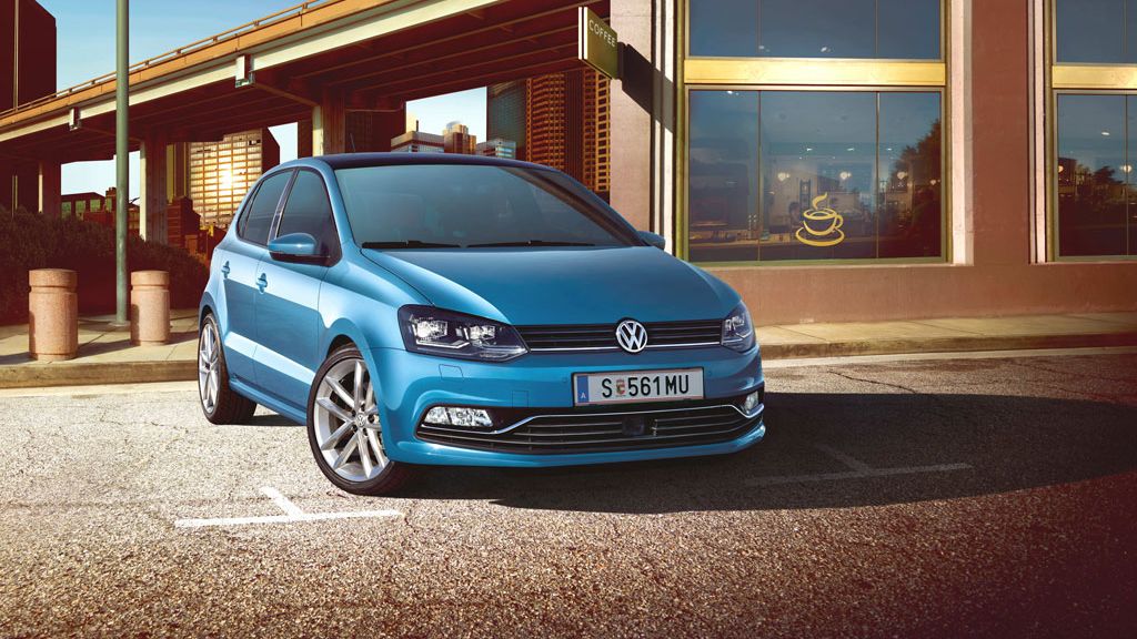 Blauer Polo steht auf einem Parkplatz vor einem Café.