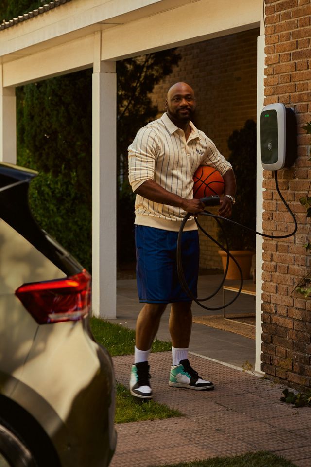 Ein Mann holt einen Ladestecker seiner Wallbox um seinen ID.3 zu laden. 