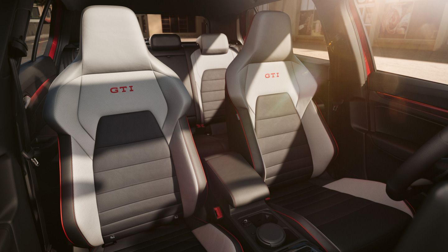 Vordersitze im VW Golf GTI mit GTI-Logo und roten Ziernähten.