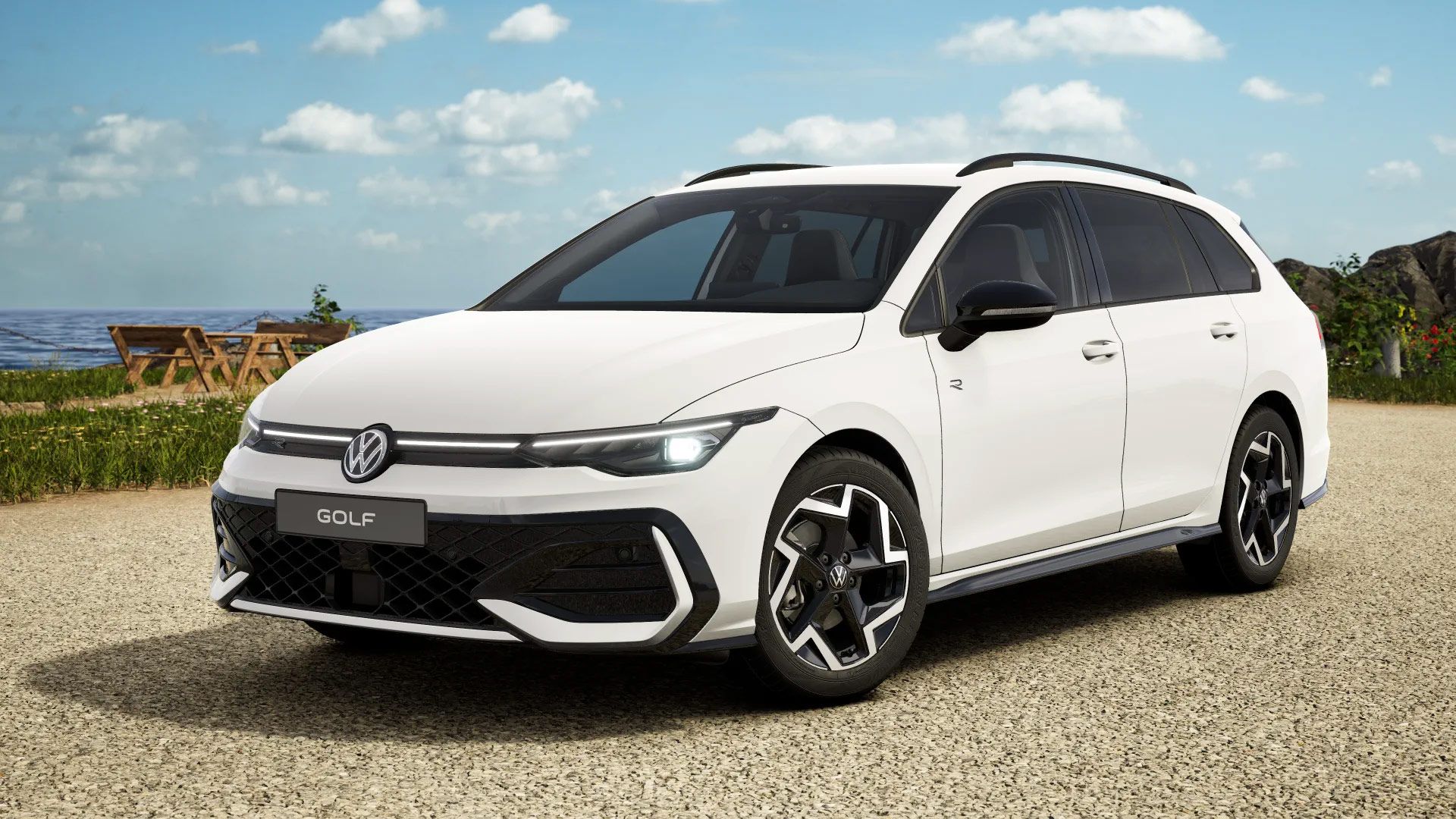 Ein weißer Volkswagen Golf Variant steht auf einem gepflasterten Weg vor einem Picknickbereich mit Holztischen und Bänken. Im Hintergrund sind das Meer und ein teilweise bewölkter Himmel zu sehen. Der Wagen hat moderne, stilvolle Designelemente und dunkle Fenster.