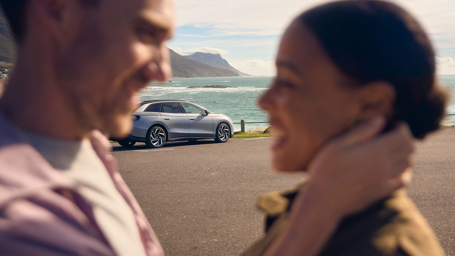 Zwei Personen umarmen sich vor einem ID.7 Tourer.