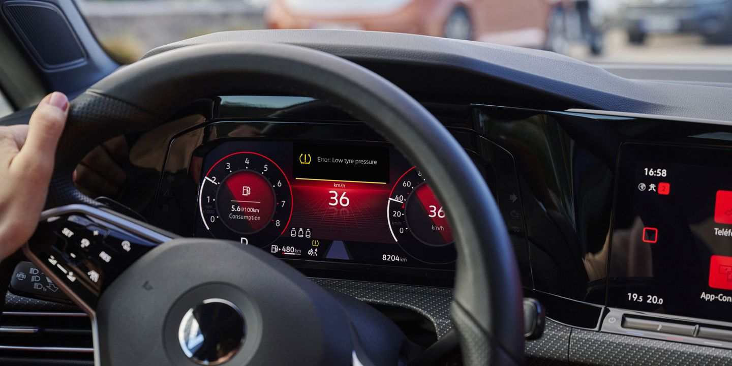 Nahaufnahme des VW-Cockpits mit beleuchtetem Warnlicht