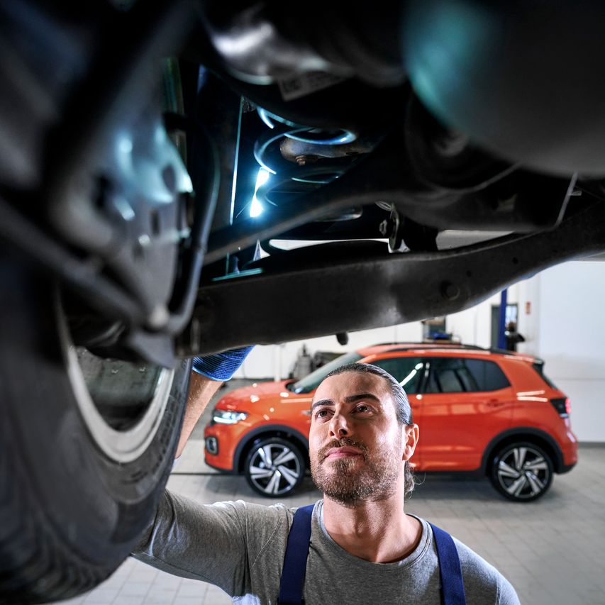 Ein VW Techniker überprüft einen Volkswagen Stoßdämpfer