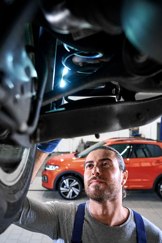 Ein VW Techniker überprüft einen Volkswagen Stoßdämpfer